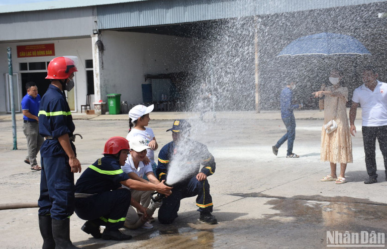 Người dân sử dụng kỹ năng sử dụng vòi phun nước dập lửa. Ảnh ANH ĐÀO
