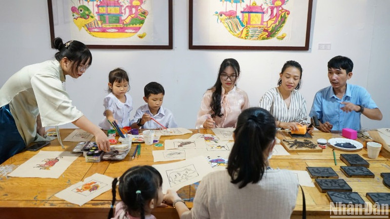 Người dân, du khách trải nghiệm in tranh Làng Sình. (Ảnh: ANH ĐÀO)