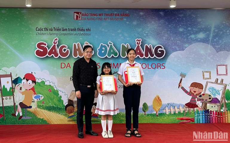 Phó Giám đốc Sở Giáo dục và Đào tạo TP Đà Nẵng Trần Nguyễn Minh Thành trao giải Nhất cho các em học sinh. (Ảnh ANH ĐÀO)