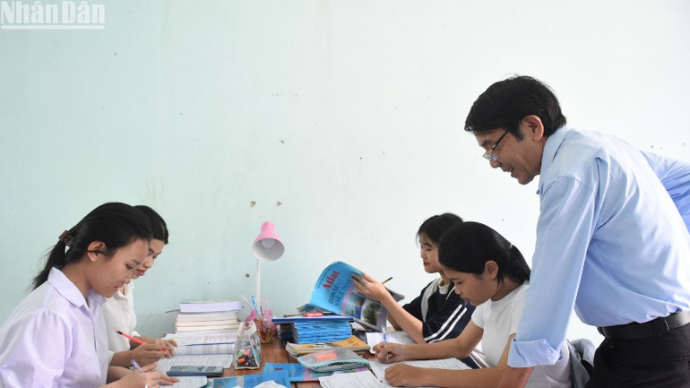 Thầy giáo Võ Trinh, Hiệu trưởng Trường trung học phổ thông Phạm Phú Thứ (xã Hòa Sơn, huyện Hòa Vang, thành phố Đà Nẵng) thăm hỏi, động viên các em học sinh lớp 12 là con em đồng bào dân tộc Cơ Tu tại khu vực nội trú của trường, dự thi Kỳ thi tốt nghiệp THPT năm 2024. (Ảnh: ANH ĐÀO)