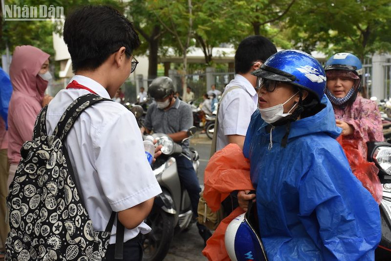 Trời mưa, nhiều thí sinh đội mưa đến điểm thi. (Ảnh: ANH ĐÀO)