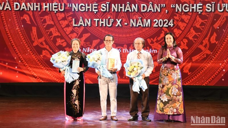 Phó Chủ tịch Ủy ban nhân dân thành phố Đà Nẵng Nguyễn Thị Anh Thi tặng hoa chúc mừng các cá nhân được phong tặng danh hiệu Nghệ sĩ nhân dân. (Ảnh: ANH ĐÀO)