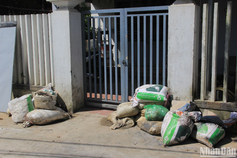 Nhà dân vẫn giữ nguyên các bao tải cát dùng để chặn, ngăn đất đá chảy vào nhà khi mưa lớn. Ảnh ANH ĐÀO