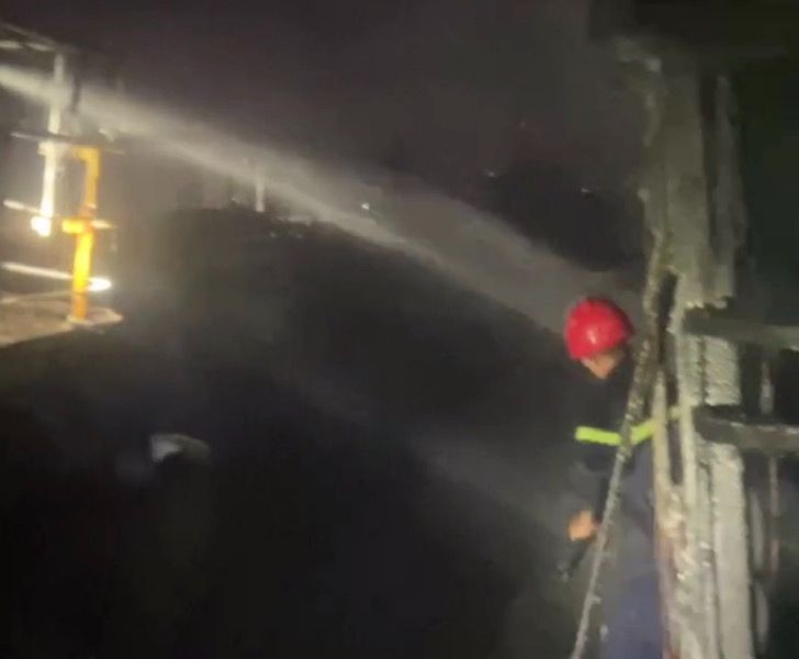 Các chiến sĩ nỗ lực khống chế ngọn lửa không để cháy lan rộng ra các tàu cá đang neo đậu chung quanh. Ảnh Công an cung cấp