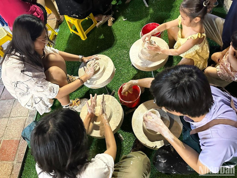 Du khách nhí trải nghiệm làm gốm tại Khu vườn tuổi thơ tối ngày 27/4. (Ảnh: ANH ĐÀO)