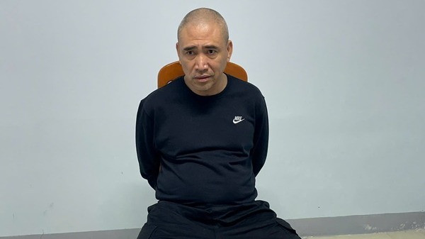 Đối tượng Trần Ngọc Anh cùng tang vật thu giữ được tại thời điểm bị bắt theo lệnh truy nã đặc biệt. (Ảnh: Công an cung cấp)