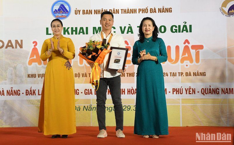 Phó Chủ tịch Hội đồng nhân dân thành phố Đà Nẵng Nguyễn Thị Anh Thi và Chủ tịch Hội Nghệ sĩ Nhiếp ảnh Việt Nam Trần Thị Thu Đông trao Huy chương Vàng cho nghệ sĩ nhiếp ảnh Nguyễn Ngọc Hòa. Ảnh: ANH ĐÀO