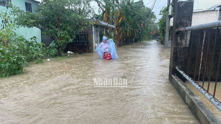 Người dân vất vả di chuyển ra khỏi khu vực ngập lụt. (Ảnh: CÔNG VINH)