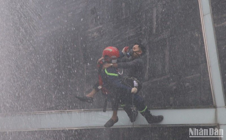 Chiến sĩ cảnh sát phòng cháy chữa cháy, cứu nạn đu dây đưa nạn nhân thoát nạn an toàn.