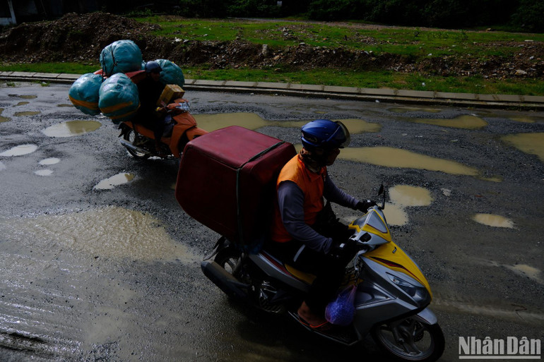Các phương tiện lưu thông lên xã Hòa Bắc phải vượt qua đoạn đường chưa thi công do người dân chưa bàn giao mặt bằng.