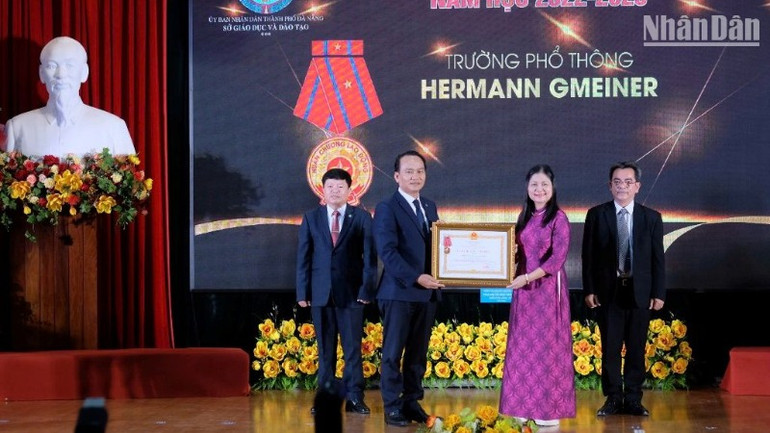 Thừa ủy quyền Chủ tịch nước, Phó Bí thư Thường trực Thành ủy Đà Nẵng Nguyễn Đình Vĩnh trao Huân chương Lao động hạng Ba cho tập thể Trường Phổ thông Hermann Gmeiner Đà Nẵng. (Ảnh: ANH ĐÀO)