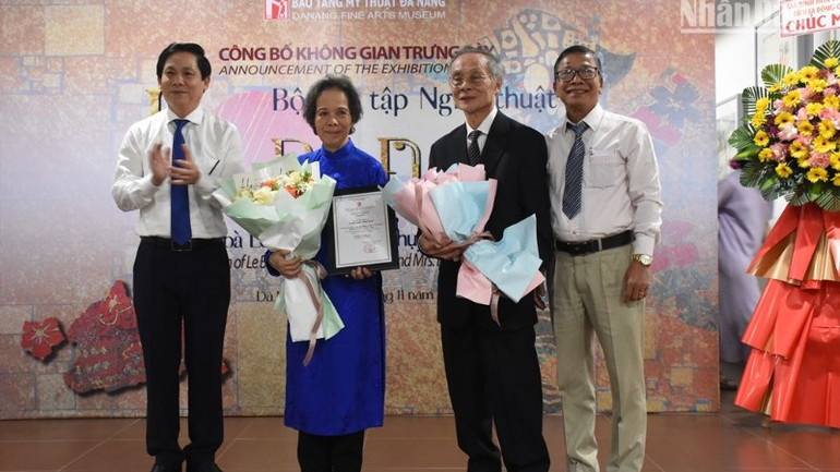 Ông Phạm Tấn Xử, Giám đốc Sở Văn hóa, thể thao thành phố Đà Nẵng và ông Hà Thanh Vân, Giám đốc Bảo tàng Mỹ thuật Đà Nẵng tặng hoa, bằng chứng nhận tri ân vợ chồng ông bà bà Lê Tất Luyện-Thụy Khuê. (Ảnh: ANH ĐÀO)
