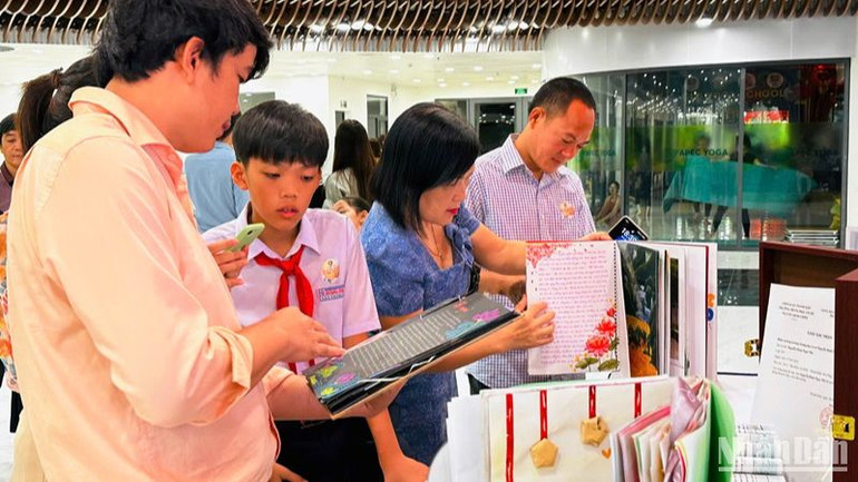 Phụ huynh và học sinh cùng xem lại những tác phẩm xuất sắc giành giải thưởng Cuộc thi “Đại sứ văn hóa đọc Đà Nẵng” năm 2024. (Ảnh: ANH ĐÀO)
