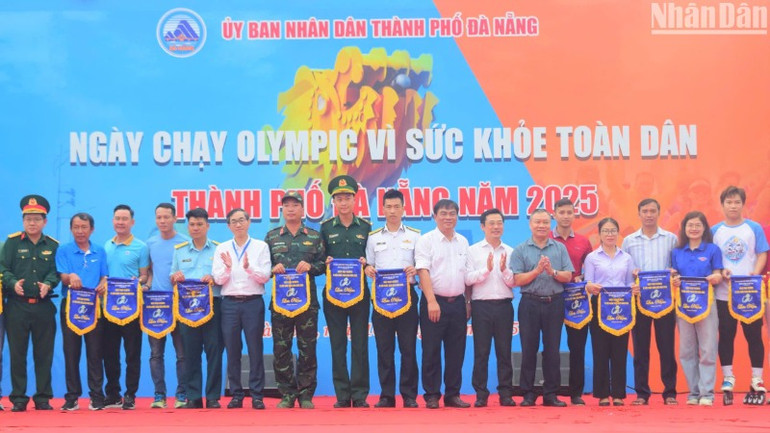 Ban tổ chức trao cờ lưu niệm cho các đơn vị tham gia Ngày chạy Olympic vì sức khỏe toàn dân năm 2025. (Ảnh: ANH ĐÀO)