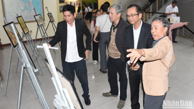 Các đại biểu tham quan không gian triển lãm “Chuyện làng” gồm hơn 60 bức ảnh kể về sự khởi đầu của các đình làng tại Đà Nẵng trong dòng chảy lịch sử. (Ảnh: ANH ĐÀO)