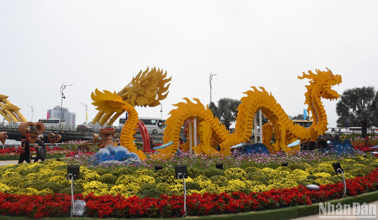 Tại điểm quảng trường phía bắc đuôi cầu Rồng là hình ảnh rồng bay với hiệu ứng phun lửa, phun khói, phun nước tạo sự vui tươi nhộn nhịp phù hợp với không khí ngày xuân. Chủ đề của điểm hoa này là “Vũ điệu xuân” với hình ảnh con rồng uốn lượn nhấp nhô theo vũ điệu. (Ảnh: ANH ĐÀO) Tại điểm quảng trường phía bắc đuôi cầu Rồng là hình ảnh rồng bay với hiệu ứng phun lửa, phun khói, phun nước tạo sự vui tươi nhộn nhịp phù hợp với không khí ngày xuân. Chủ đề của điểm hoa này là “Vũ điệu xuân” với hình ảnh con rồng uốn lượn nhấp nhô theo vũ điệu. (Ảnh: ANH ĐÀO)