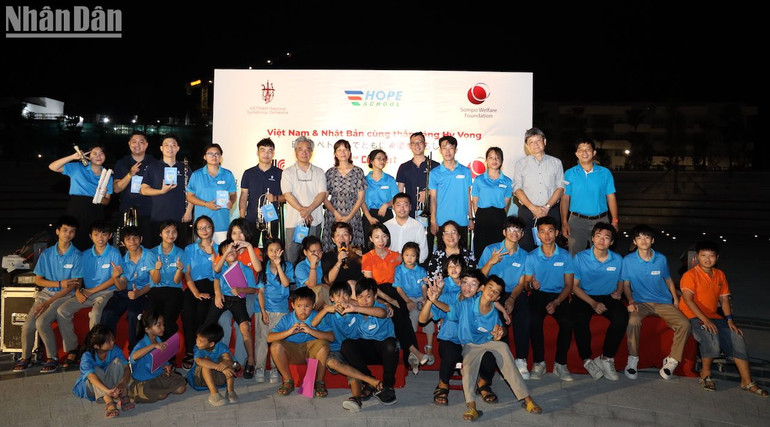 Ông Taketoshi Nagaoka, nhạc trưởng Honna Tetsuji và các nghệ sĩ của Dàn nhạc giao hưởng Việt Nam và các em học sinh Trường Hy Vọng. (Ảnh: ANH ĐÀO)