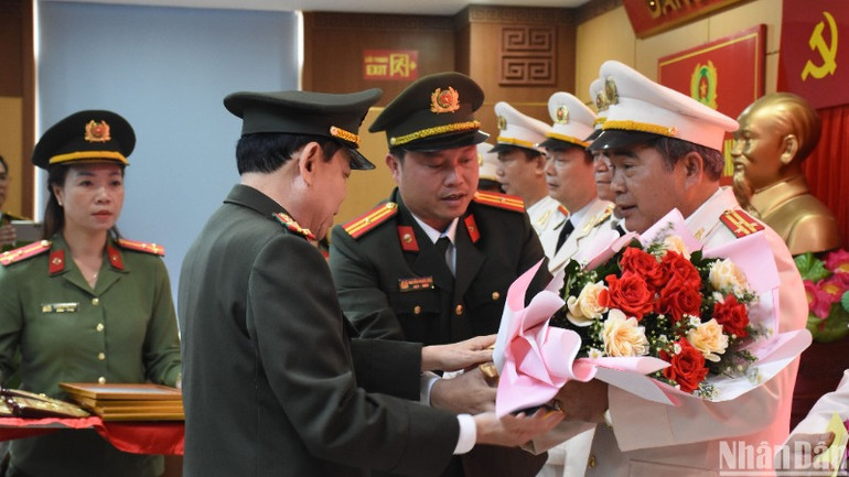 Đại tá Trần Đình Liên, Phó Bí thư, Phó Giám đốc Công an thành phố Đà Nẵng trao quyết định nghỉ hưu và tặng hoa cảm ơn các đồng chí cấp phó trưởng phòng nghỉ hưu trước tuổi. (Ảnh: ANH ĐÀO)