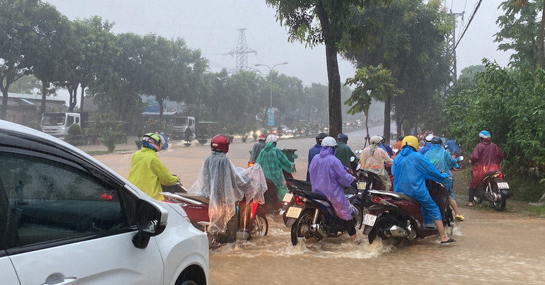 Phương tiện lưu thông khó khăn khi nước ngập tràn hết mặt đường sáng nay.