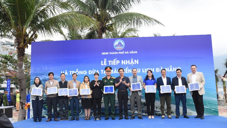 Phó Chủ tịch Ủy ban nhân dân thành phố Đà Nẵng Trần Chí Cường tặng bảng biểu trưng cảm ơn sự chung tay đóng góp của các cơ quan, doanh nghiệp đã đồng hành cùng thành phố trong chiến dịch vận động trồng dừa tại các bãi biển. (Ảnh: ANH ĐÀO)