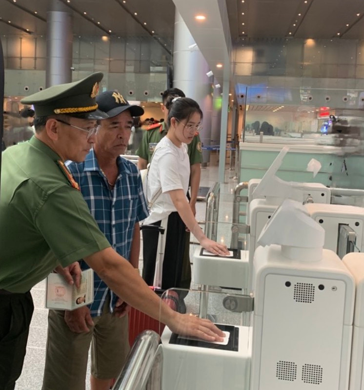 Lực lượng chức năng hướng dẫn du khách quét hộ chiếu qua Autogate. (Ảnh: Công an cửa khẩu Cảng hàng không quốc tế Đà Nẵng cung cấp)