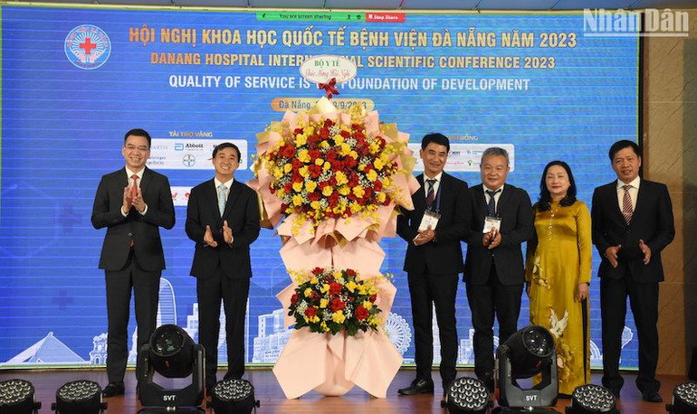 Thứ trưởng Y tế Trần Văn Thuấn tặng hoa chúc mừng Ban Giám đốc Bệnh viện Đà Nẵng. (Ảnh: ANH ĐÀO)