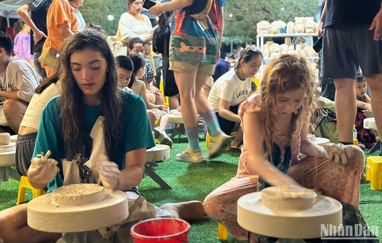 Du khách nước ngoài trải nghiệm làm gốm. (Ảnh: ANH ĐÀO)