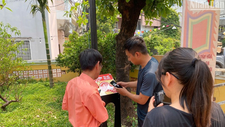 Lắp đặt bảng gắn chip NFC trong Dự án "Yêu lắm Việt Nam" tại Di tích quốc gia Đình làng Hải Châu. (Ảnh: ANH ĐÀO)