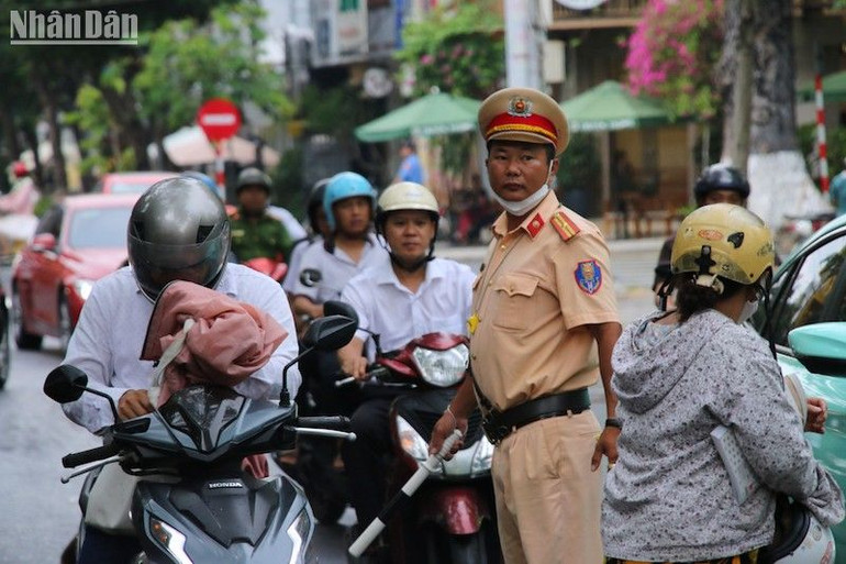 Lực lượng cảnh sát giao thông phân luồng, hướng dẫn phụ huynh rời cổng điểm thi. (Ảnh: ANH ĐÀO)