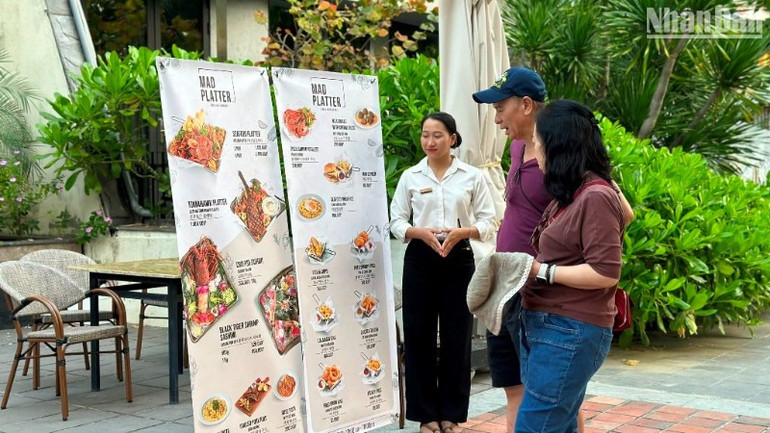 Khách du lịch tìm hiểu, chọn lựa các món ăn đặc sản tại một nhà hàng trên tuyến đường Võ Nguyên Giáp, quận Sơn Trà, thành phố Đà Nẵng. (Ảnh: ANH ĐÀO)