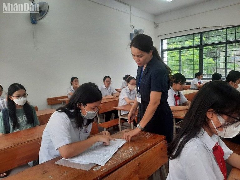 Cán bộ coi thi hướng dẫn thí sinh hoàn thành các thủ tục, giấy tờ thi. (Ảnh: ANH NGỌC)