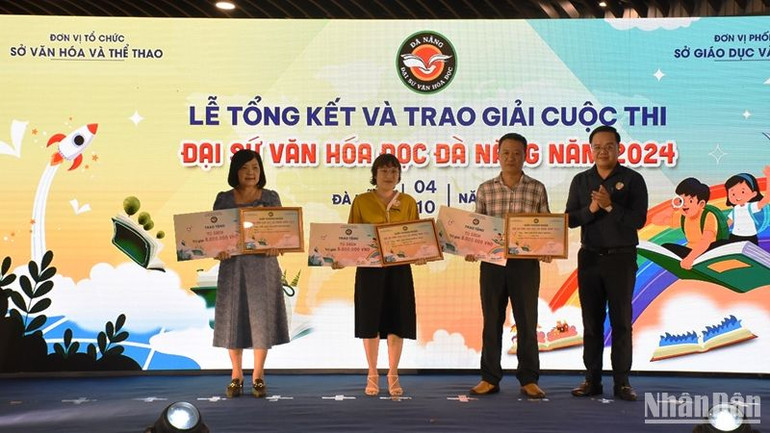 Phó Giám đốc Sở Giáo dục và Đào tạo thành phố Đà Nẵng Trần Nguyễn Minh Thành trao Giải thưởng là một tủ sách trị giá 5 triệu đồng dành cho các “Trường có nhiều thí sinh đạt giải nhất”. (Ảnh: ANH ĐÀO)