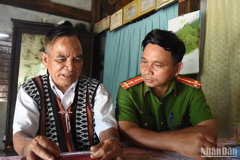 Thượng úy Bùi Văn Hoàng bên bố ruột là già làng Bùi Văn Siêng. (ẢNH ANH ĐÀO)