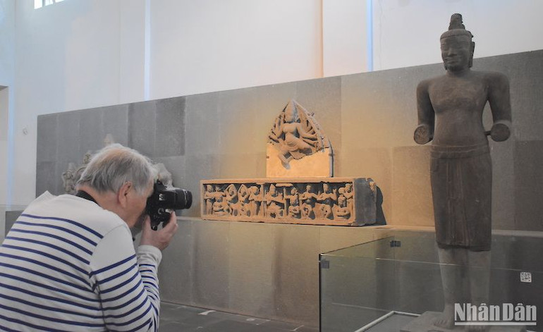 Du khách nước ngoài lưu lại hình ảnh Tượng thần Shiva Mỹ Sơn C1 - báu vật quốc gia. (Ảnh ANH ĐÀO)
