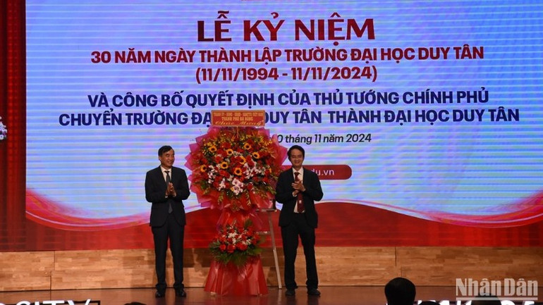 Phó Bí thư Thành ủy, Chủ tịch Ủy ban nhân dân thành phố Đà Nẵng Lê Trung Chinh tặng hoa chúc mừng TS. Lê Nguyên Bảo, Hiệu trưởng Đại học Duy Tân. (Ảnh: ANH ĐÀO)