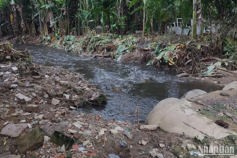 Nguồn nước đen ngòm chảy lộ thiên qua khu dân cư. (Ảnh: ANH ĐÀO)