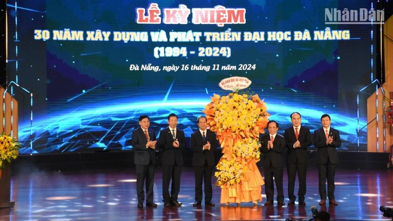 Bộ trưởng Giáo dục và Đào tạo Nguyễn Kim Sơn tặng hoa chúc mừng Đại học Đà Nẵng 30 năm xây dựng, phát triển. (Ảnh: ANH ĐÀO)