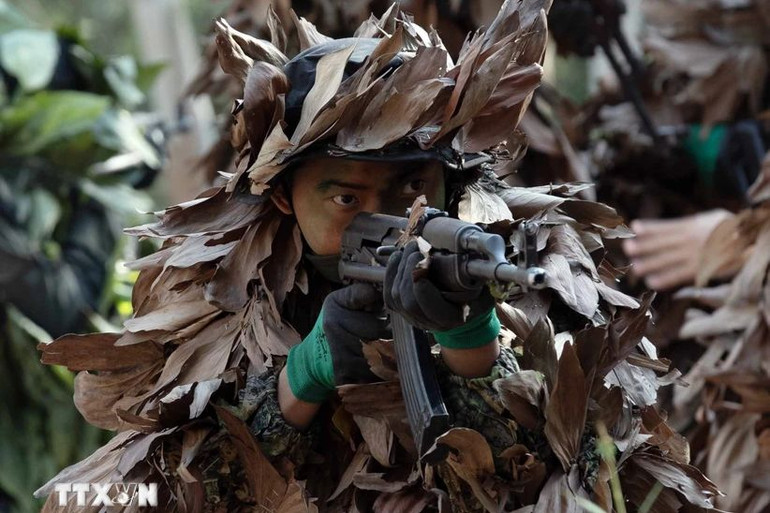 Các chiến sĩ Cảnh sát cơ động chống khủng bố nguỵ trang dưới lớp lá cây và dường như tàng hình trong không gian rừng núi. (Ảnh: TTXVN)