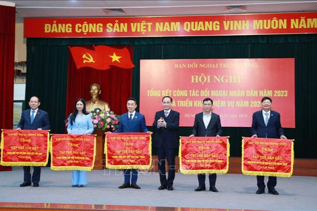 Đồng chí Lê Hoài Trung, Bí thư Trung ương Đảng, Trưởng Ban Đối ngoại Trung ương trao Cờ thi đua cho các tập thể có thành tích xuất sắc. (Ảnh: TTXVN)