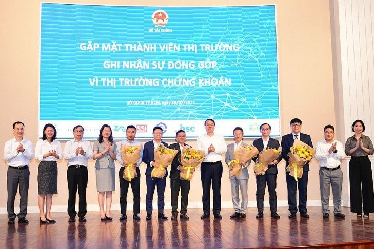 Thứ trưởng Nguyễn Đức Chi (thứ 6 từ trái sang) tặng hoa cảm ơn các thành viên thị trường ngày 28/7/2022.
