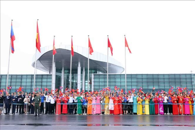 Đông đảo nhân dân Thủ đô Hà Nội cùng cán bộ, nhân viên Đại sứ quán và lưu học sinh Lào ra sân bay quốc tế Nội Bài chào đón Tổng Bí thư, Chủ tịch nước Lào Thongloun Sisoulith cùng Phu nhân và Đoàn đại biểu cấp cao Đảng, Nhà nước Lào thăm cấp Nhà nước tới Việt Nam. (Ảnh: TTXVN)