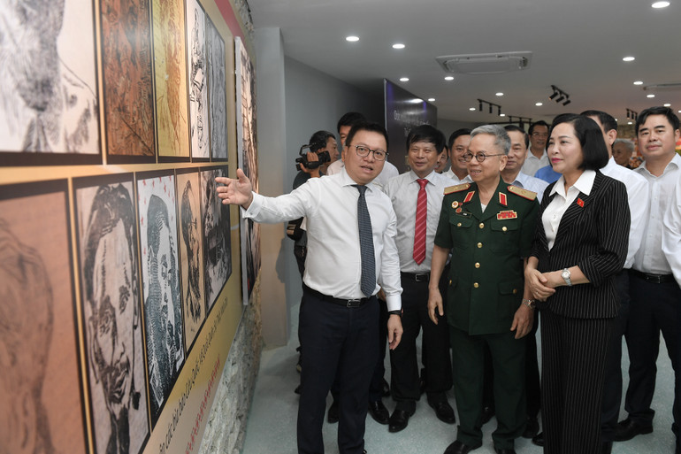 Nhà báo Lê Quốc Minh giới thiệu về những hiện vật và không gian của Trường dạy làm báo Huỳnh Thúc Kháng cho các đại biểu.