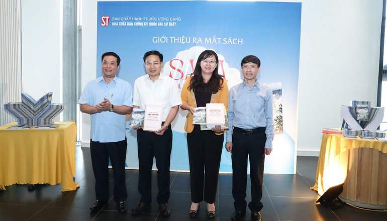 Đồng chí Võ Văn Bé, Phó Giám đốc - Phó Tổng Biên tập và đồng chí Nguyễn Thái Bình, Phó Giám đốc Nhà xuất bản trao sách tặng các đại biểu.