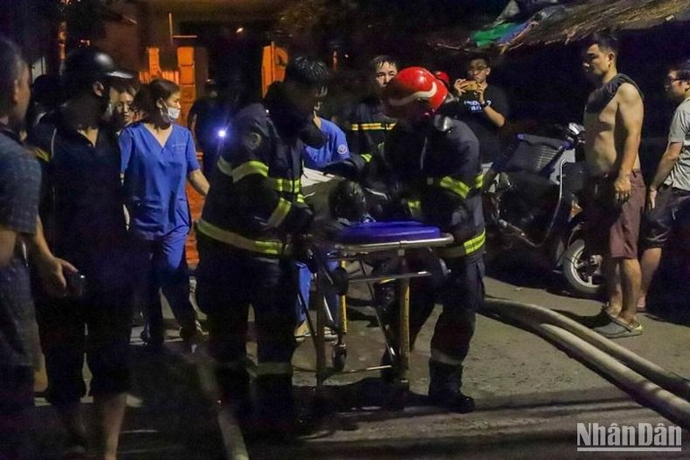 Lực lượng chữa cháy đưa nạn nhân ra ngoài.