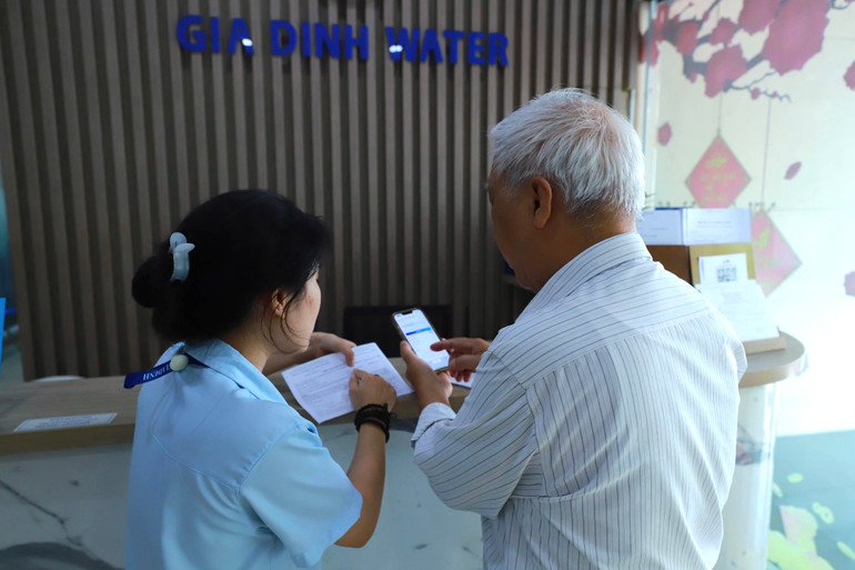 Nhân viên Công ty cổ phần Cấp nước Gia Định hướng dẫn khách hàng sử dụng dịch vụ “24H” để giải quyết nhanh những nhu cầu phát sinh ngay trong ngày.