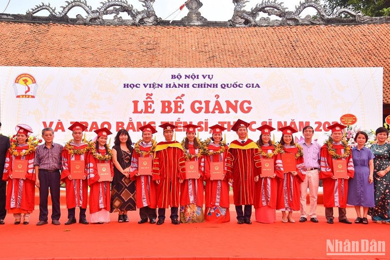 Thứ trưởng Nội vụ Triệu Văn Cường, Giám đốc Học viện Hành chính Quốc gia Nguyễn Bá Chiến và các đại biểu chụp ảnh lưu niệm cùng các tân Tiến sĩ. (Ảnh: NHẬT QUANG)