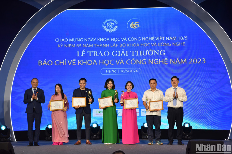 Ông Nguyễn Phương Tuấn, Phó Chủ nhiệm Ủy ban Khoa học, Công nghệ và Môi trường của Quốc hội và ông Phạm Minh Tuấn, Phó Tổng Biên tập Tạp chí Cộng sản trao giải Nhì cho các tác giả, đại diện nhóm tác giả đoạt giải. (Ảnh: NHẬT QUANG)