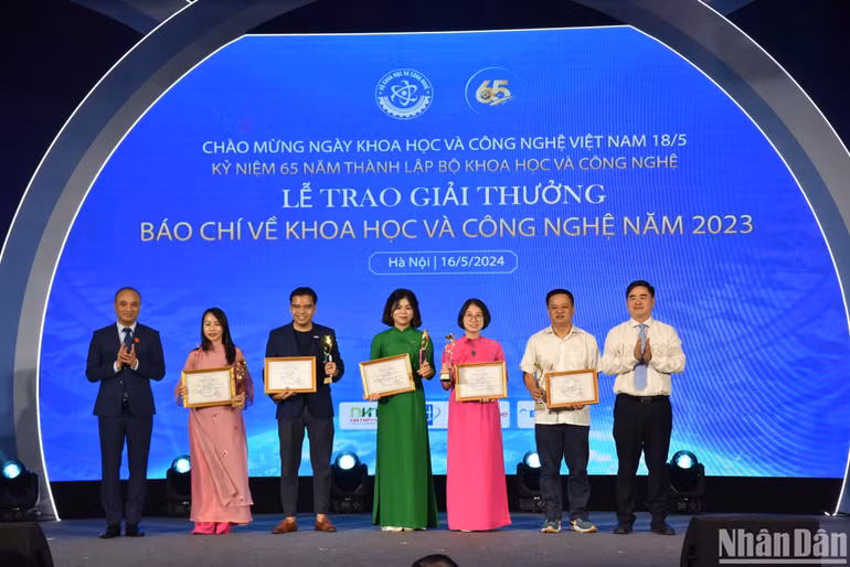 Ông Nguyễn Phương Tuấn, Phó Chủ nhiệm Ủy ban Khoa học, Công nghệ và Môi trường của Quốc hội và ông Phạm Minh Tuấn, Phó Tổng Biên tập Tạp chí Cộng sản trao giải Nhì cho các tác giả, đại diện nhóm tác giả đoạt giải. (Ảnh: NHẬT QUANG)
