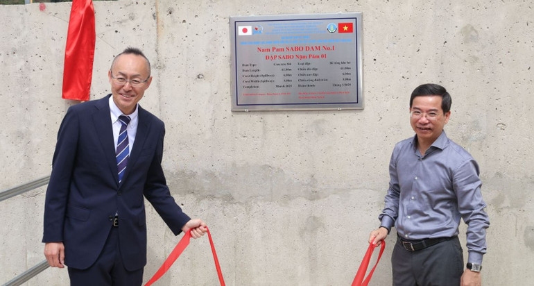 Ông Kobayashi Yosuke, Trưởng đại diện JICA tại Việt Nam và ông Nguyễn Trường Sơn, Phó Cục trưởng Cục Quản lý đê điều và phòng, chống thiên tai kéo băng biển thông tin đập Sabo. (Ảnh: THẾ ĐOÀN)