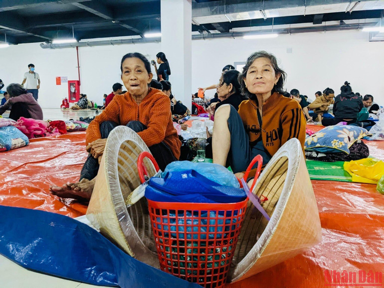 Bà Mai Thị Phi, 61 tuổi và bà Võ Thị Đố, 82 tuổi mang theo đôi dép mới và đôi nón bọc bao nylon tới điểm trú bão ở xã Bình Đông, huyện Bình Sơn.